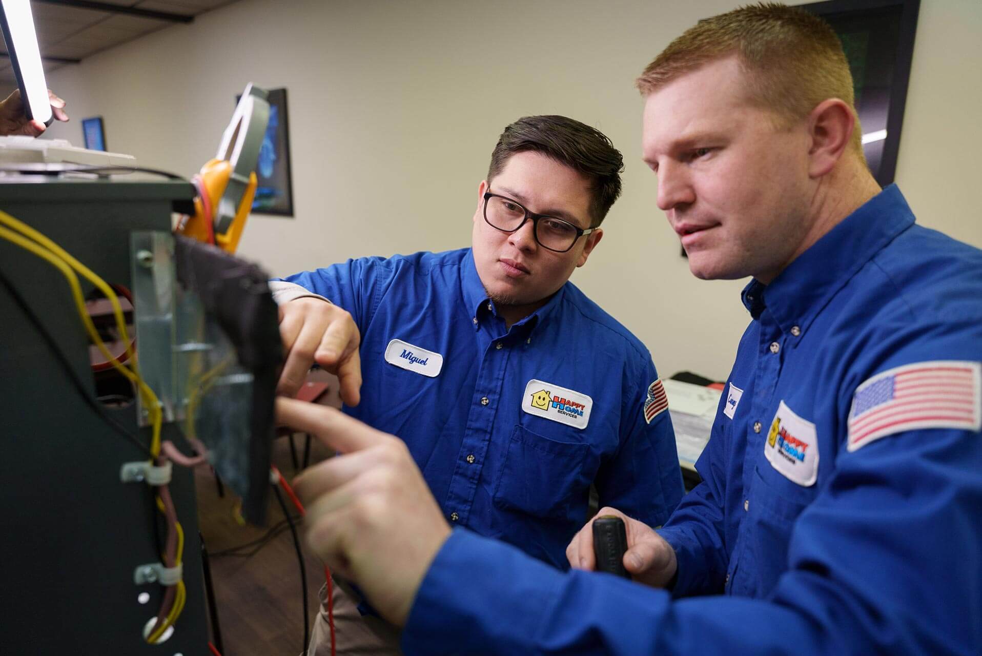 - Happy Home Services | Durham, NC Two-Happy-Home-Services-technician-working-on-a-heating-unit