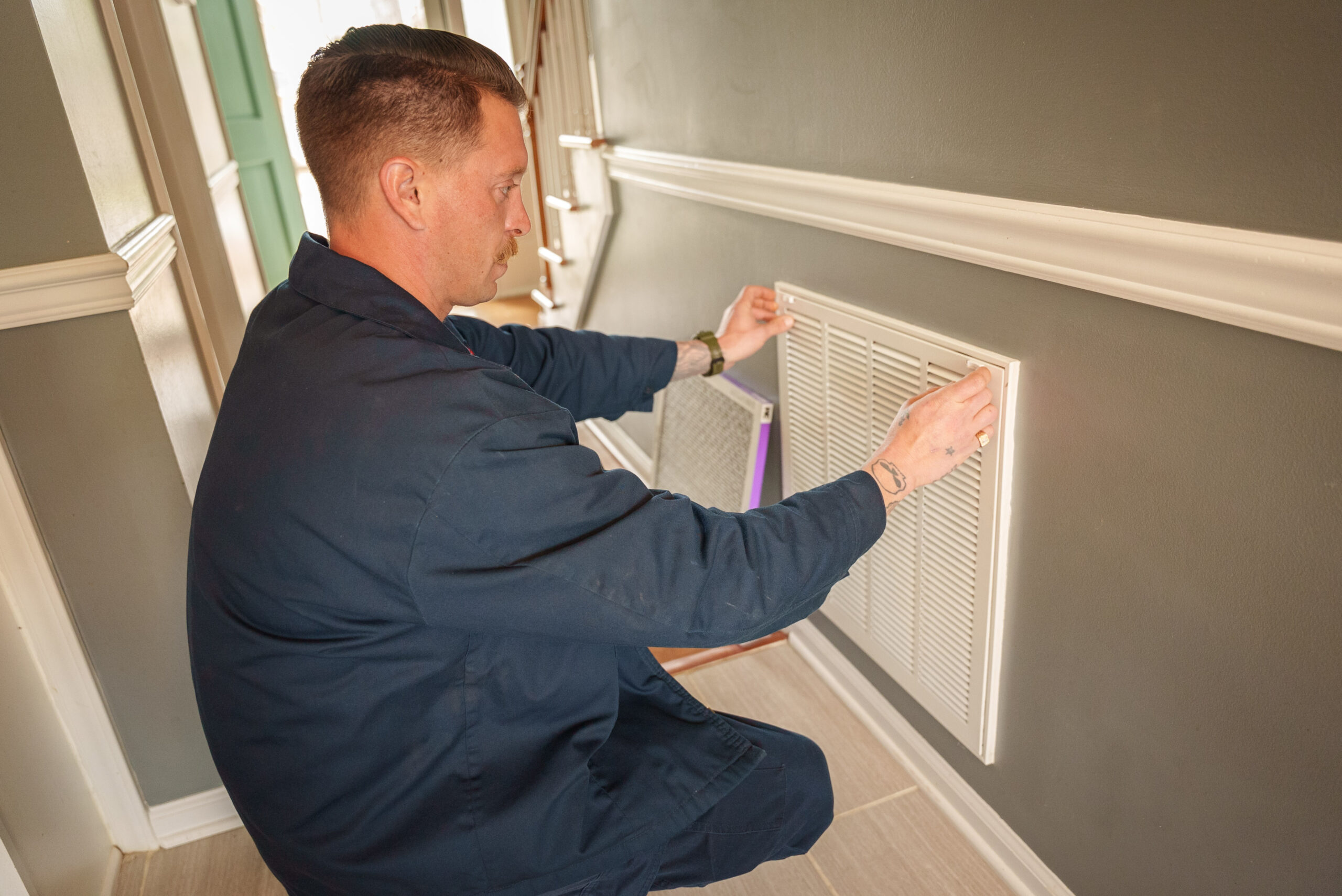 A Happy Home Services technician changing an air filter - Happy Home Services | Durham, NC A Happy Home Services technician changing an air filter