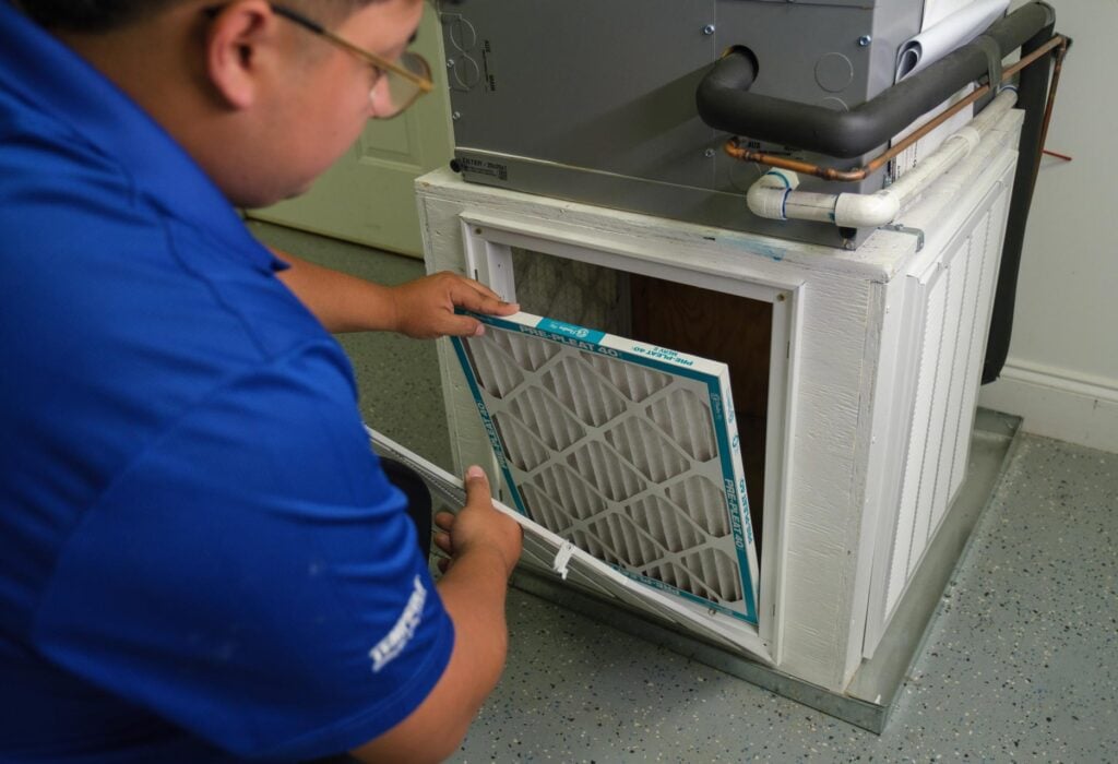 - Happy Home Services | Durham, NC Technician working on a furnace