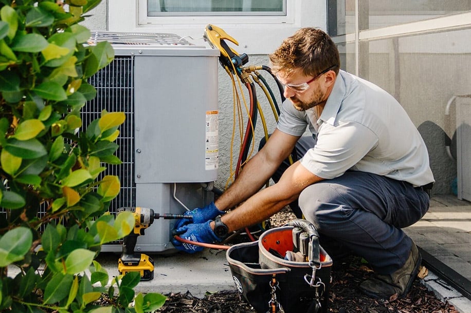 - Happy Home Services | Durham, NC technician replacing an air conditioner